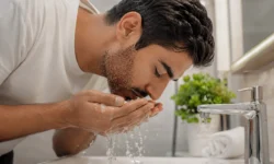 مرد ایرانی در حال شستشوی ملایم صورت پس از کاشت ریش با آب ولرم طبق مراقبت‌های بعد از پیوند ریش